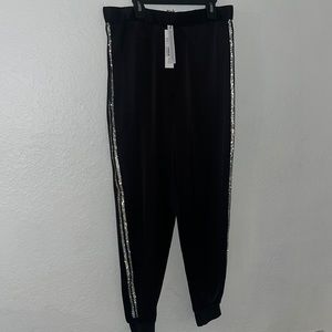 Stylish Alice + Olivia black joggers with rhinestone stripes on the side